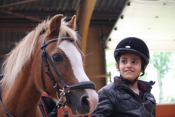 EK Rotterdam laat kinderen van Huize Thomas kennismaken met paarden
